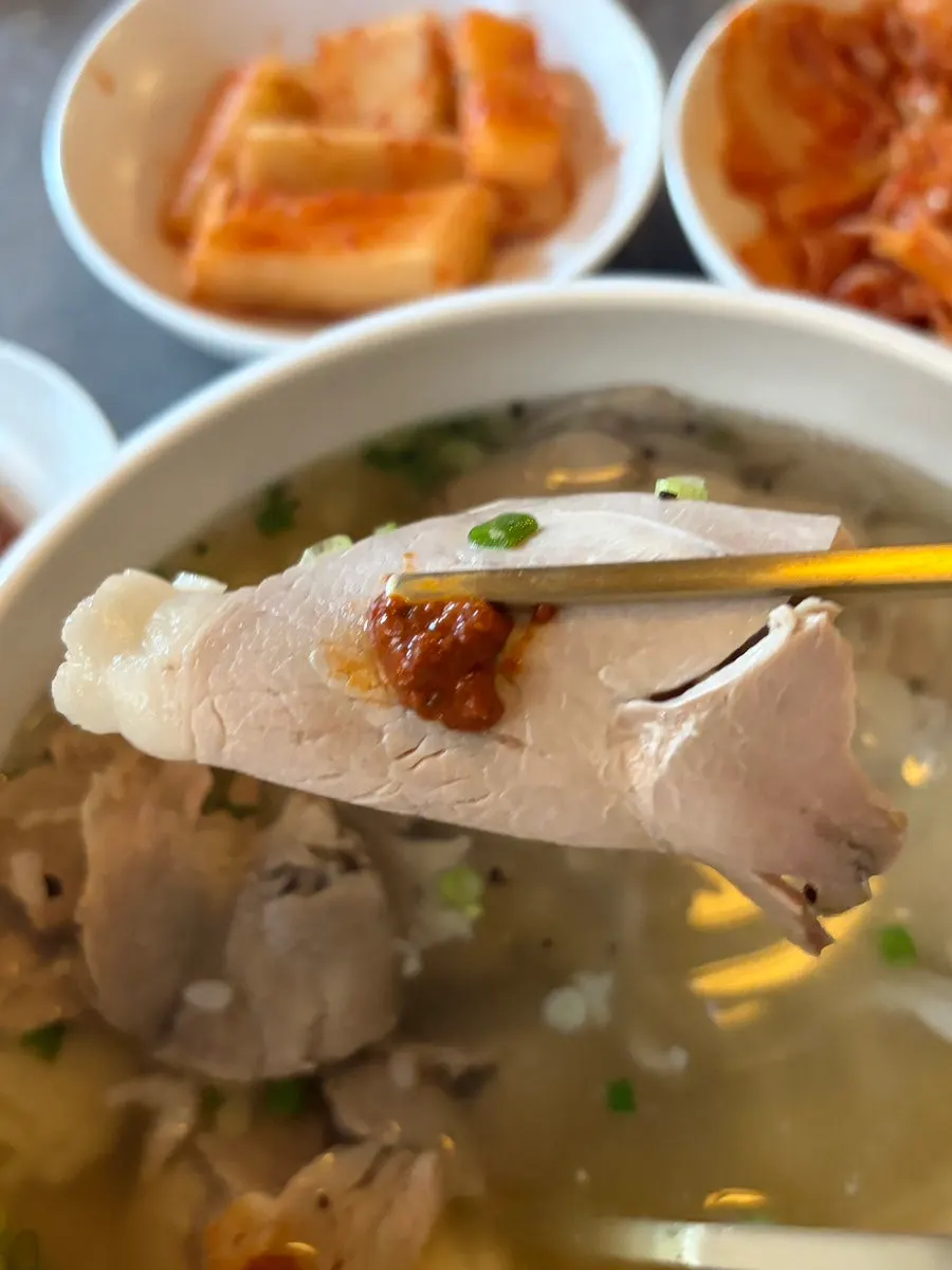 A piece of gomtang meat topped with dipping sauce