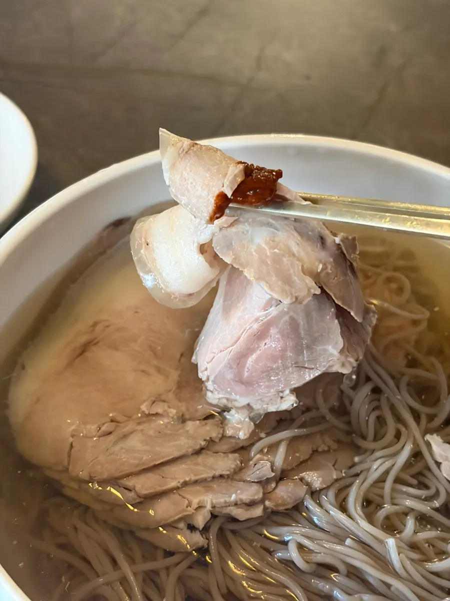 Close-up of the Pyeongyang naengmyeon broth and toppings
