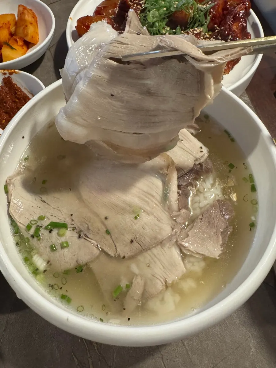 숟가락으로 떠올린 맑은 곰탕 국물