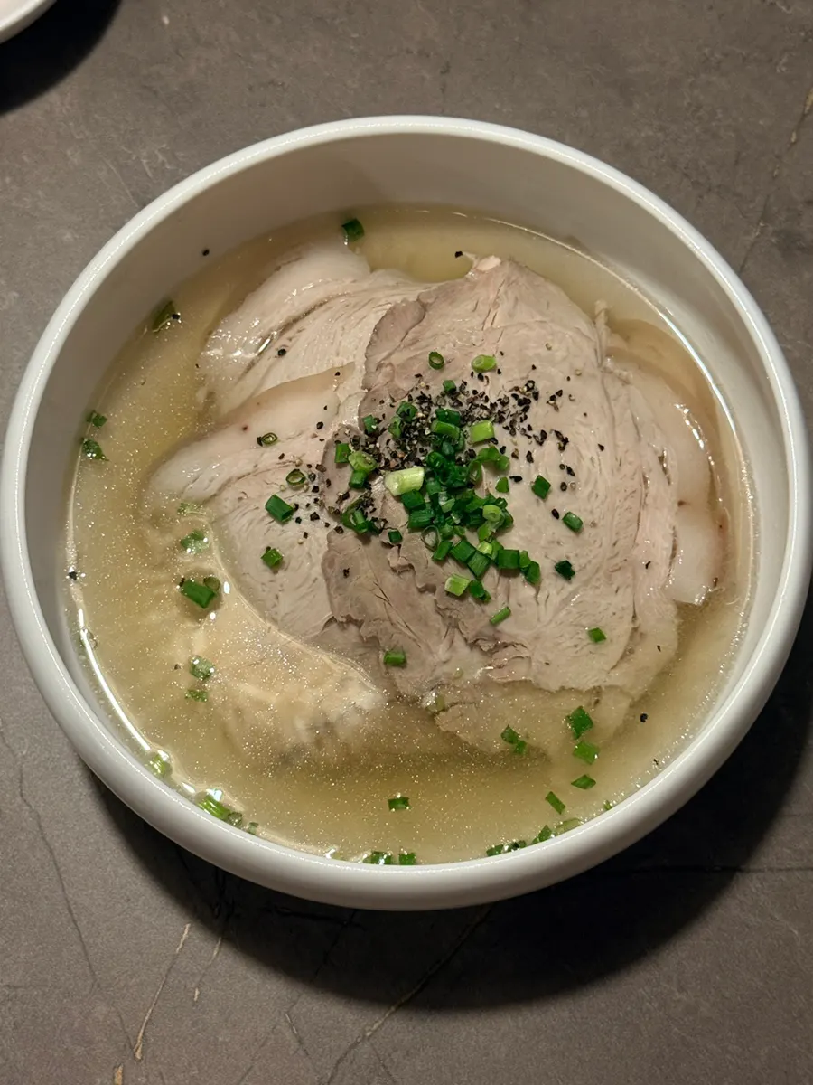 Anok's clear gomtang served in a brass bowl