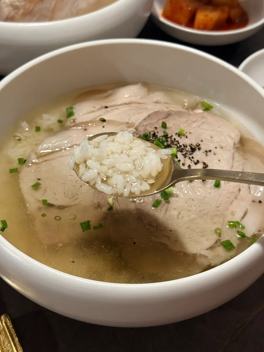 Close-up of clear gomtang topped with thinly sliced meat