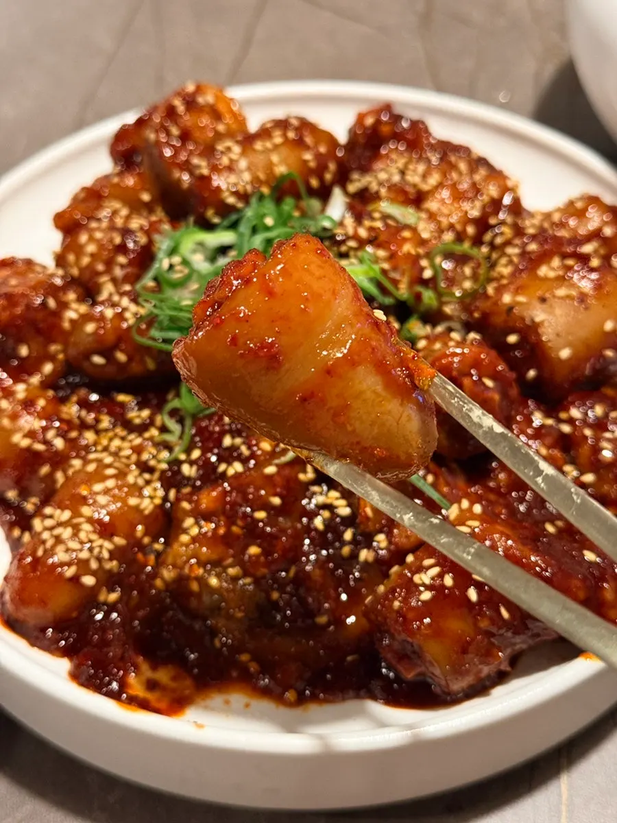Chewy pork tail jjim skin held up with chopsticks