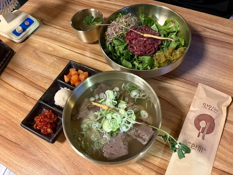 Table spread of beef gomtang and yukhoe bibimbap