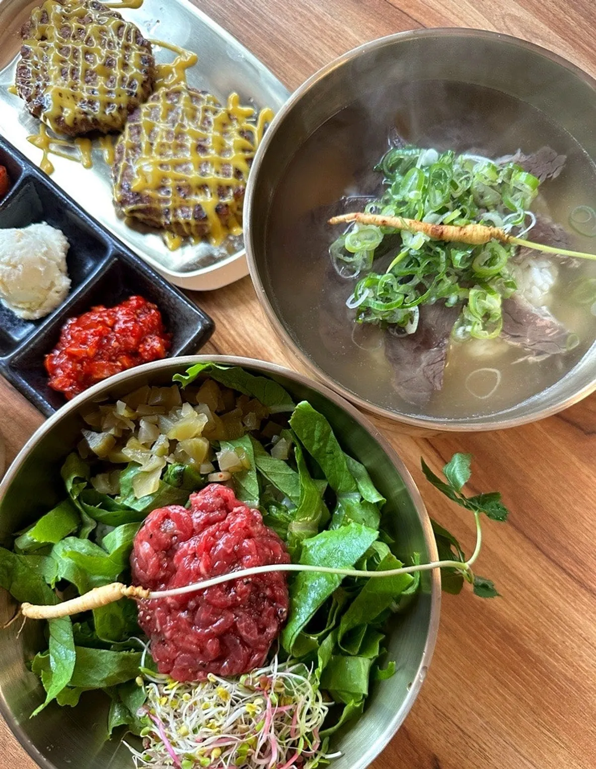 Beef gomtang and yukhoe bibimbap table setting at Baengni Gomtang