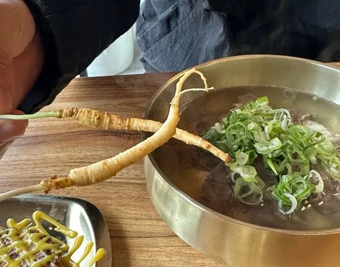 A bite of gomtang topped with squid jeotgal