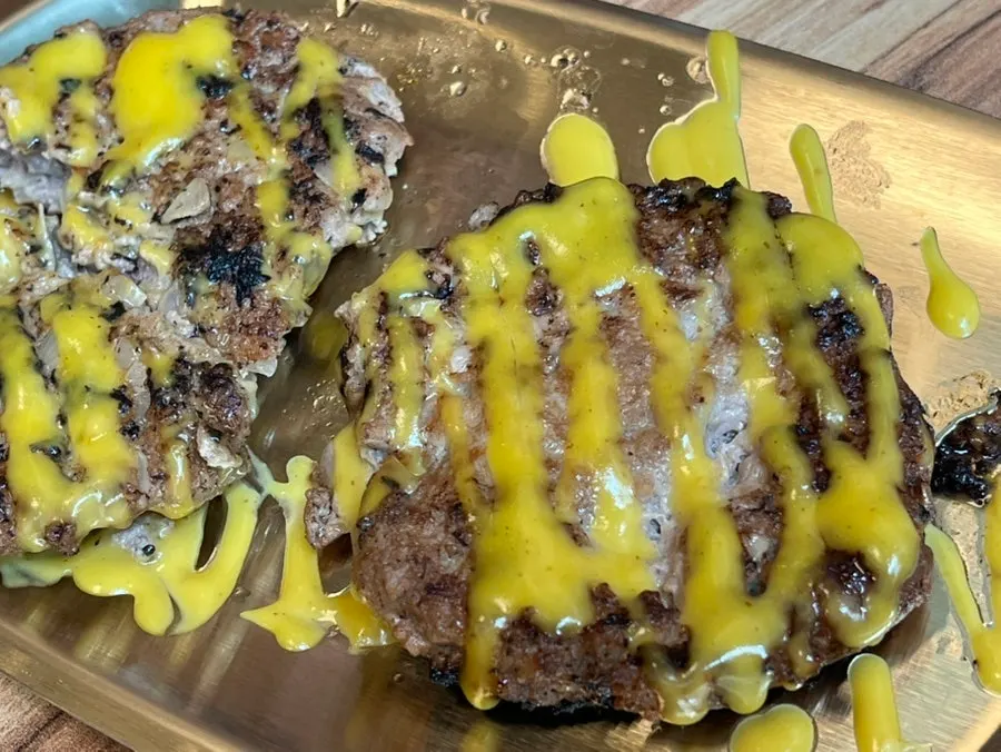 노란 소스가 뿌려진 떡갈비 한 접시