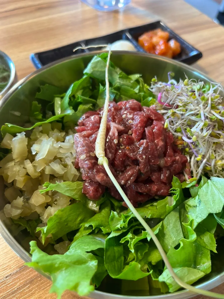 Beef soy sauce yukhoe bibimbap generously topped with raw beef