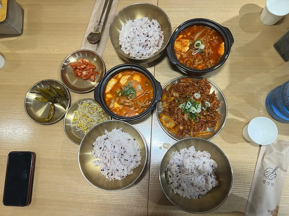 Top-down view of two stews, bulgogi and three bowls of rice