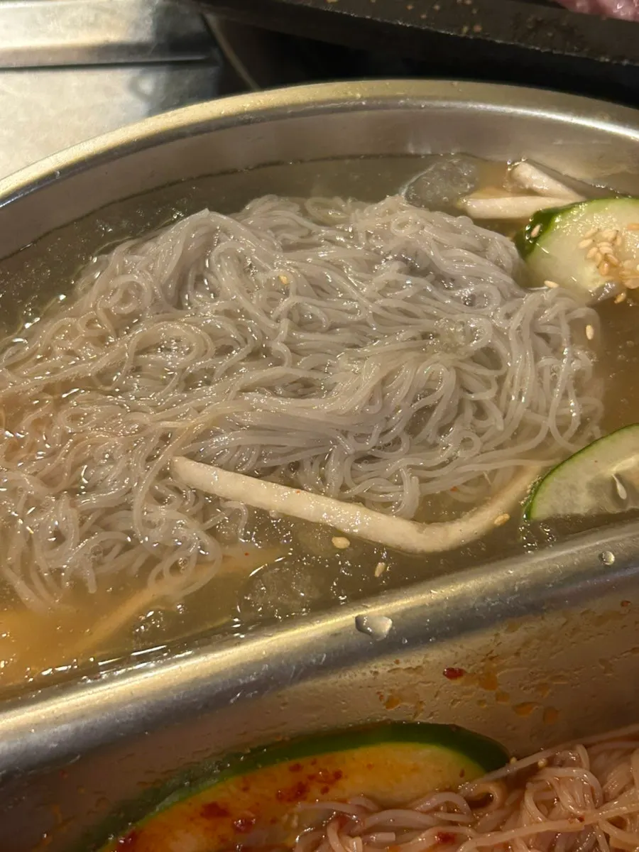 Half-and-half naengmyeon served with grilled meat