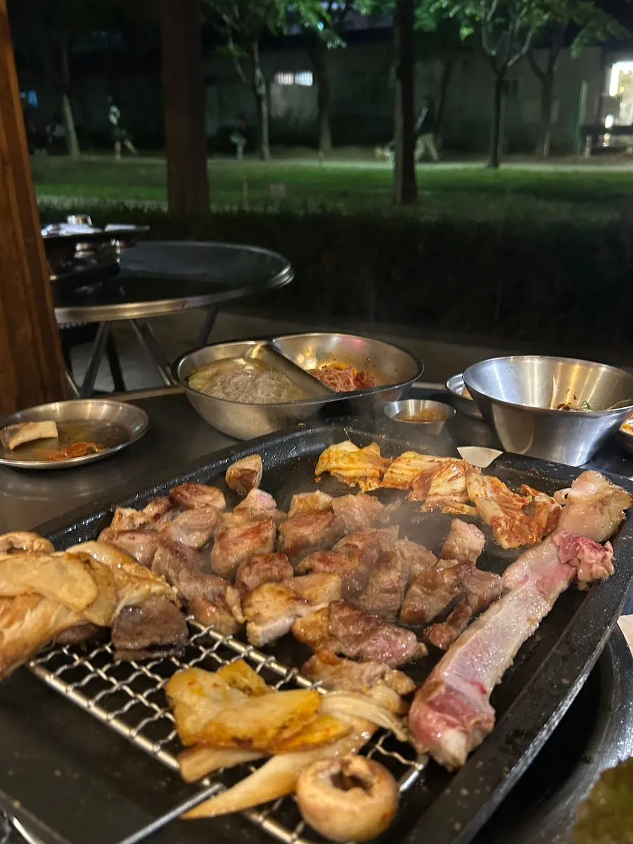 Grilled meat enjoyed at a forest-path-side table