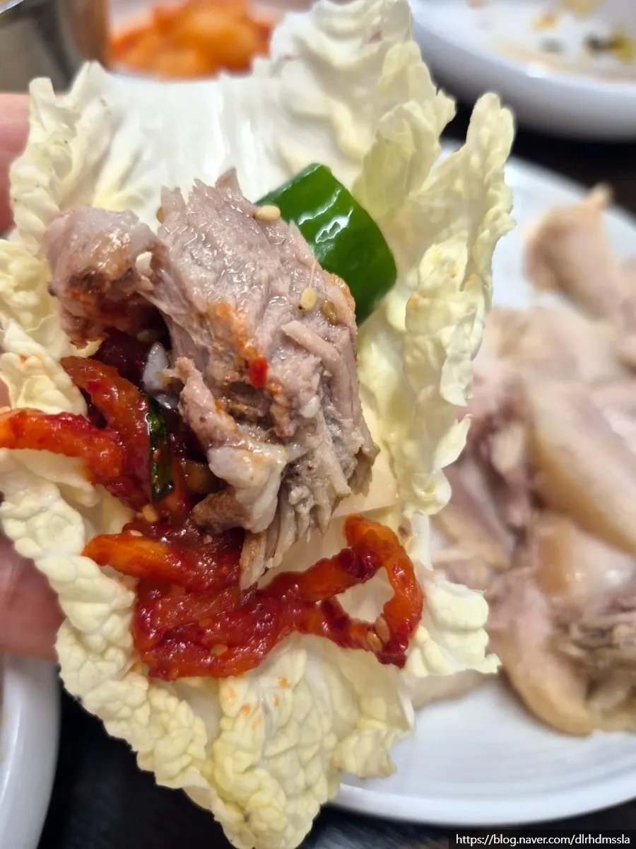 Bossam suyuk placed on inner cabbage leaf with radish salad