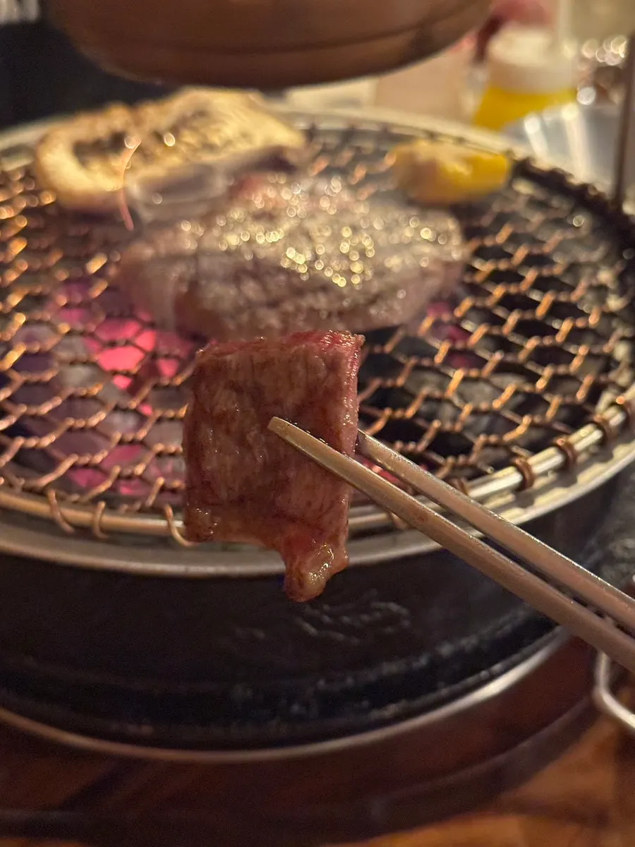 Staff grilling meat over charcoal for guests
