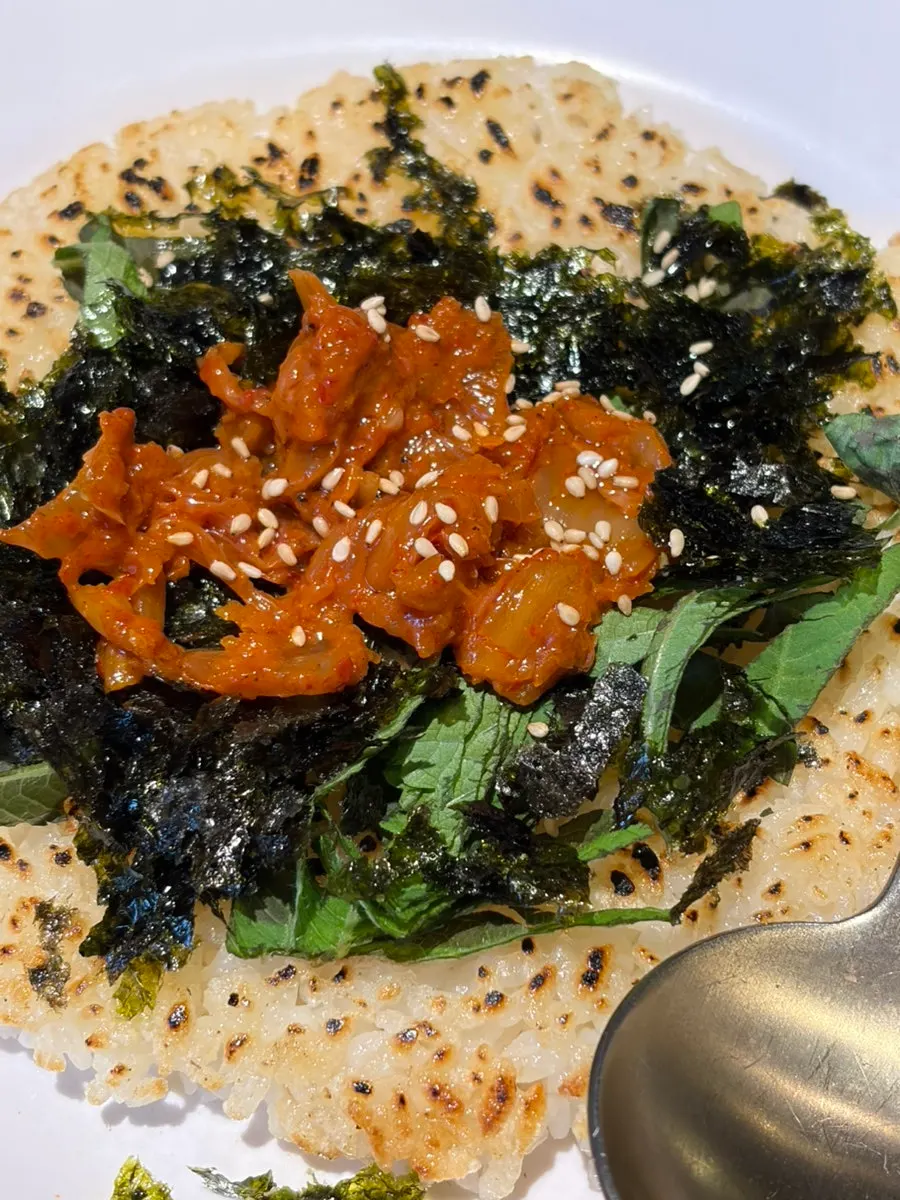Ongbap topped with stir-fried kimchi and perilla leaves
