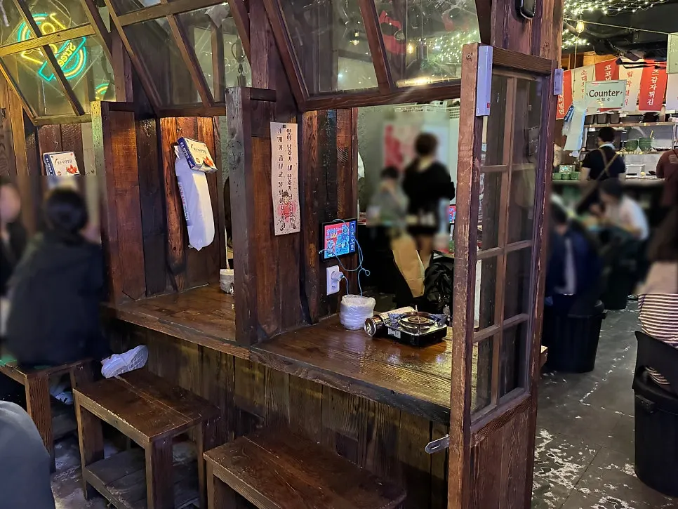 Outdoor pocha-style tables lit with neon signs