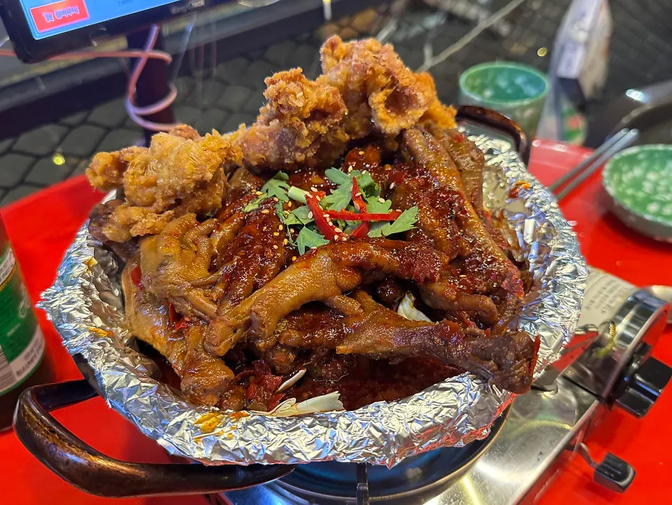 A pan of soup chicken feet topped with fried chicken skin