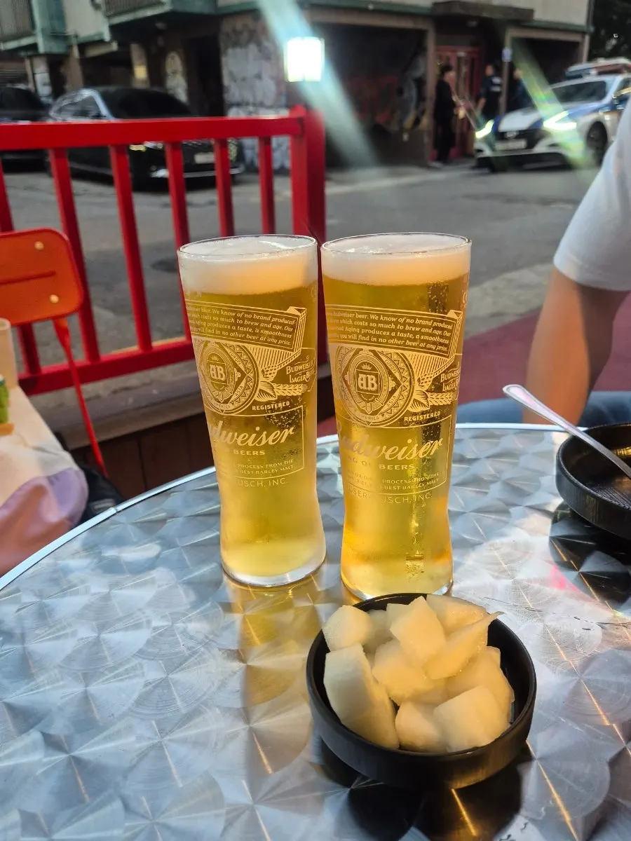 A glass of Budweiser draft beer on the outdoor table