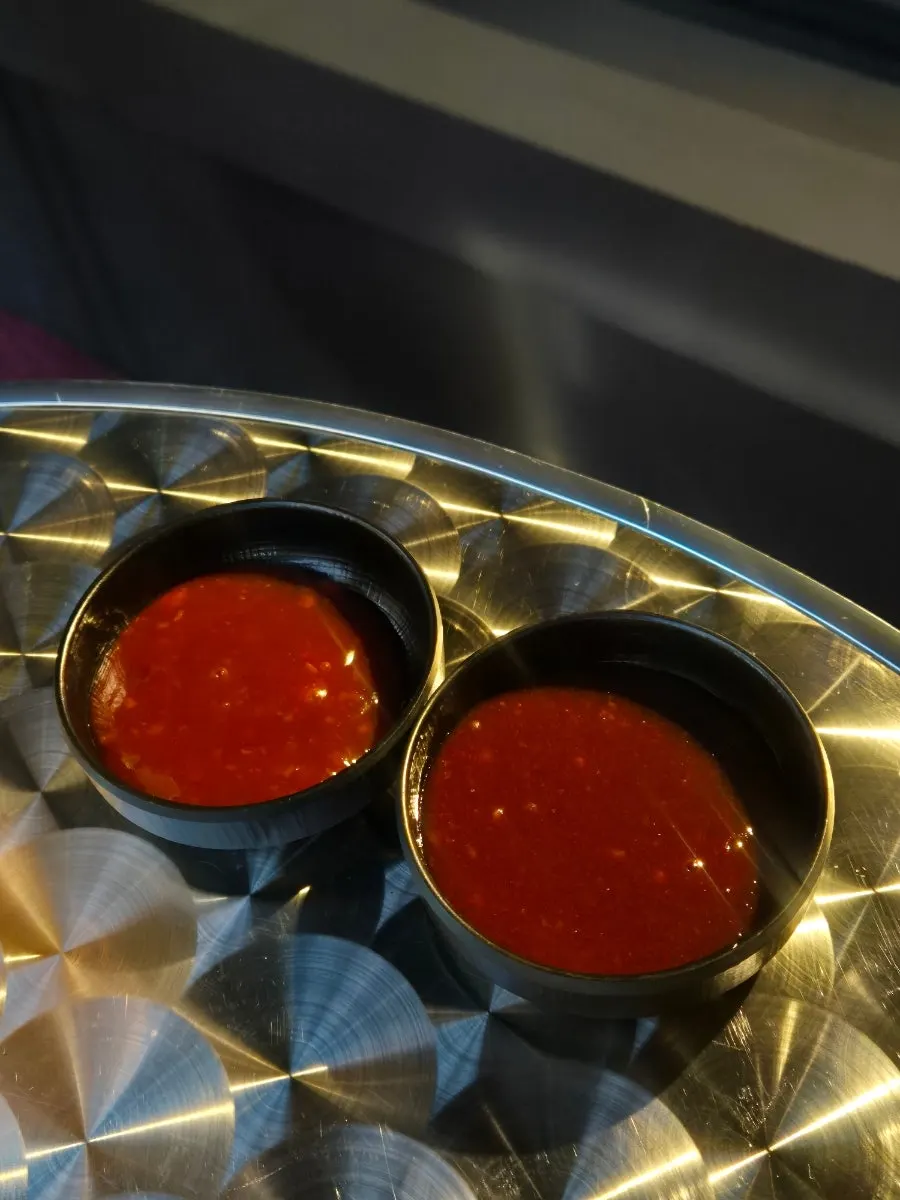 Two dipping sauces, sweet and spicy, served with the chicken