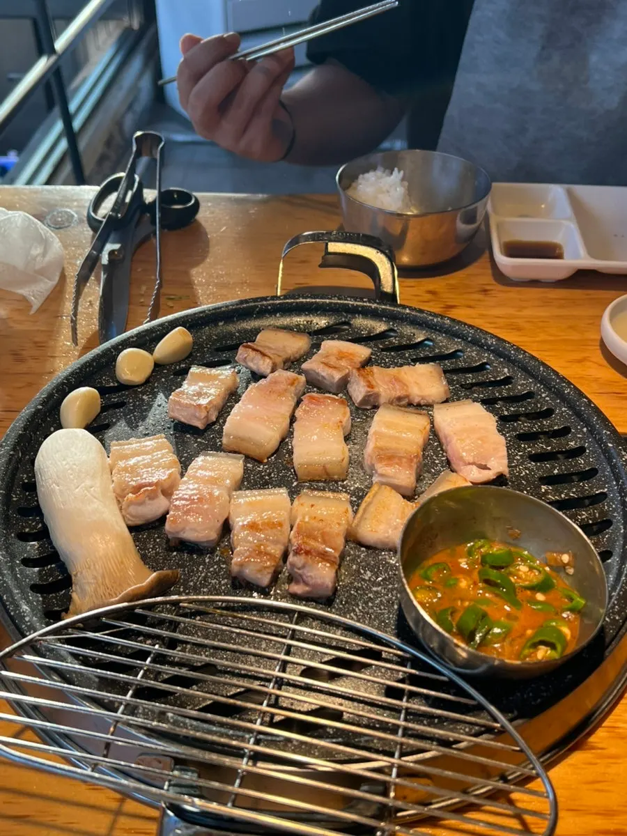 불판에서 노릇하게 구워지는 소금오겹살