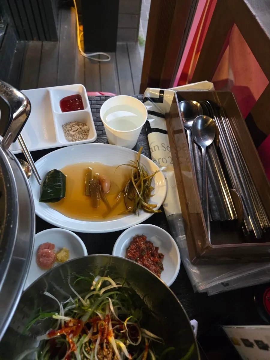 Table spread with meat and banchan for four people