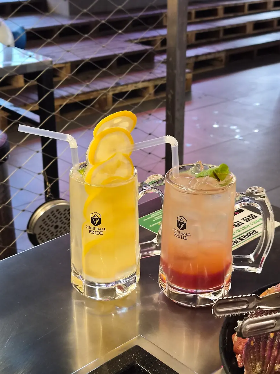 Fresh lemon highball with a long frozen lemon strip, next to a grapefruit highball