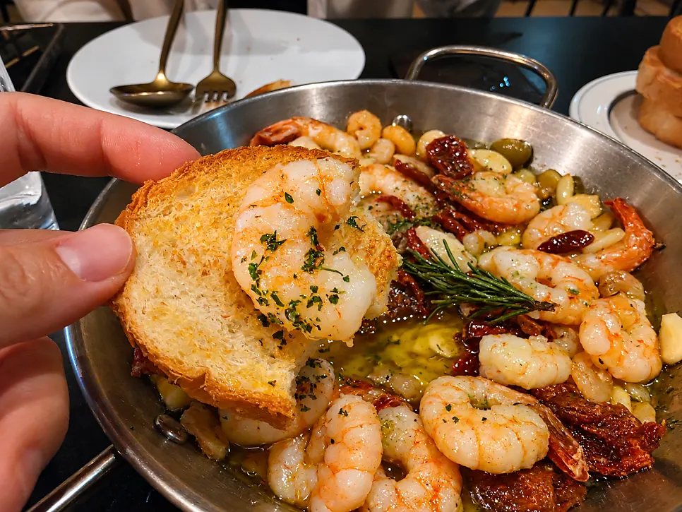 Baguette dipped into the gambas oil