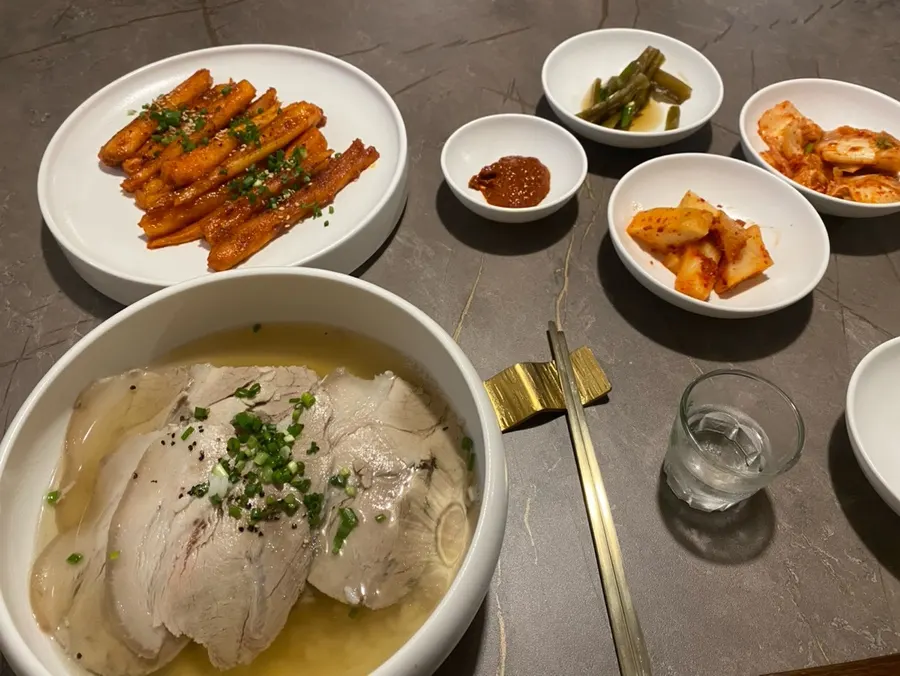 A bite of deodeok gui topped with seasoning sauce