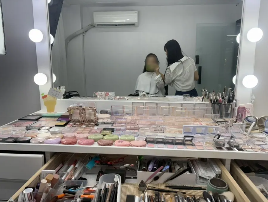 Pink-tone dress-tour makeup being applied