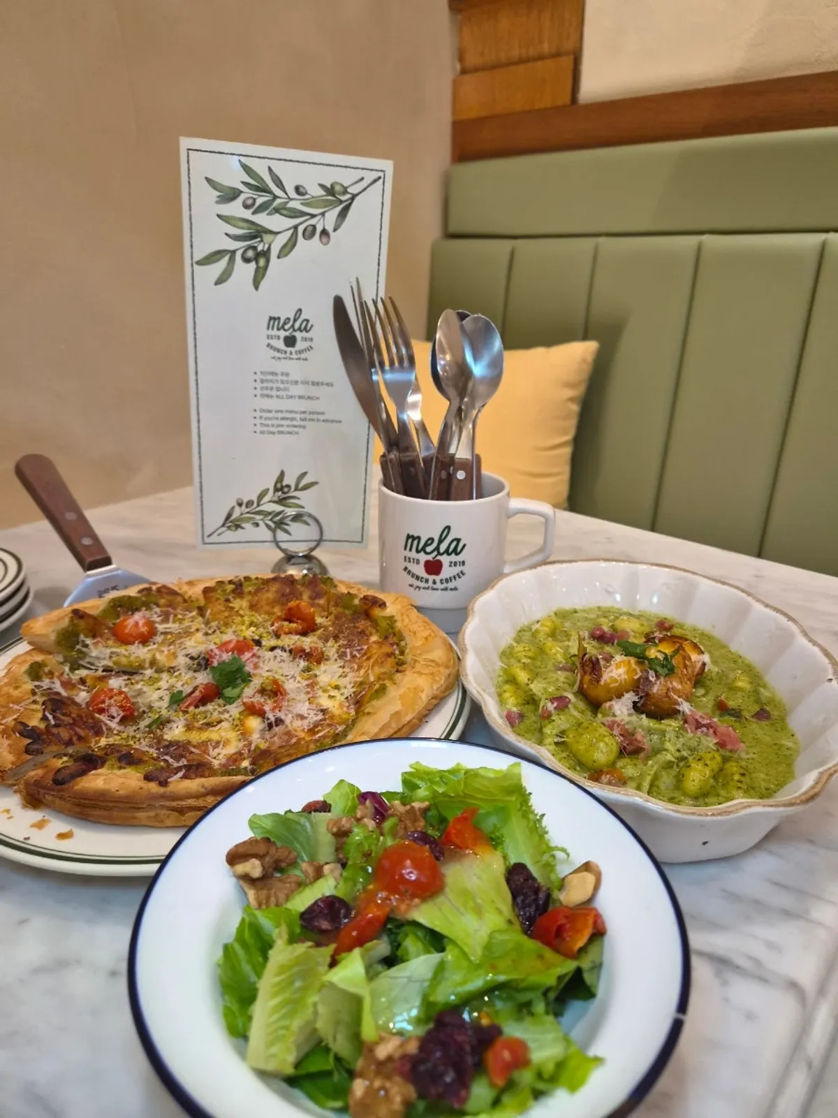 Table set with gnocchi, pizza, and mini salad