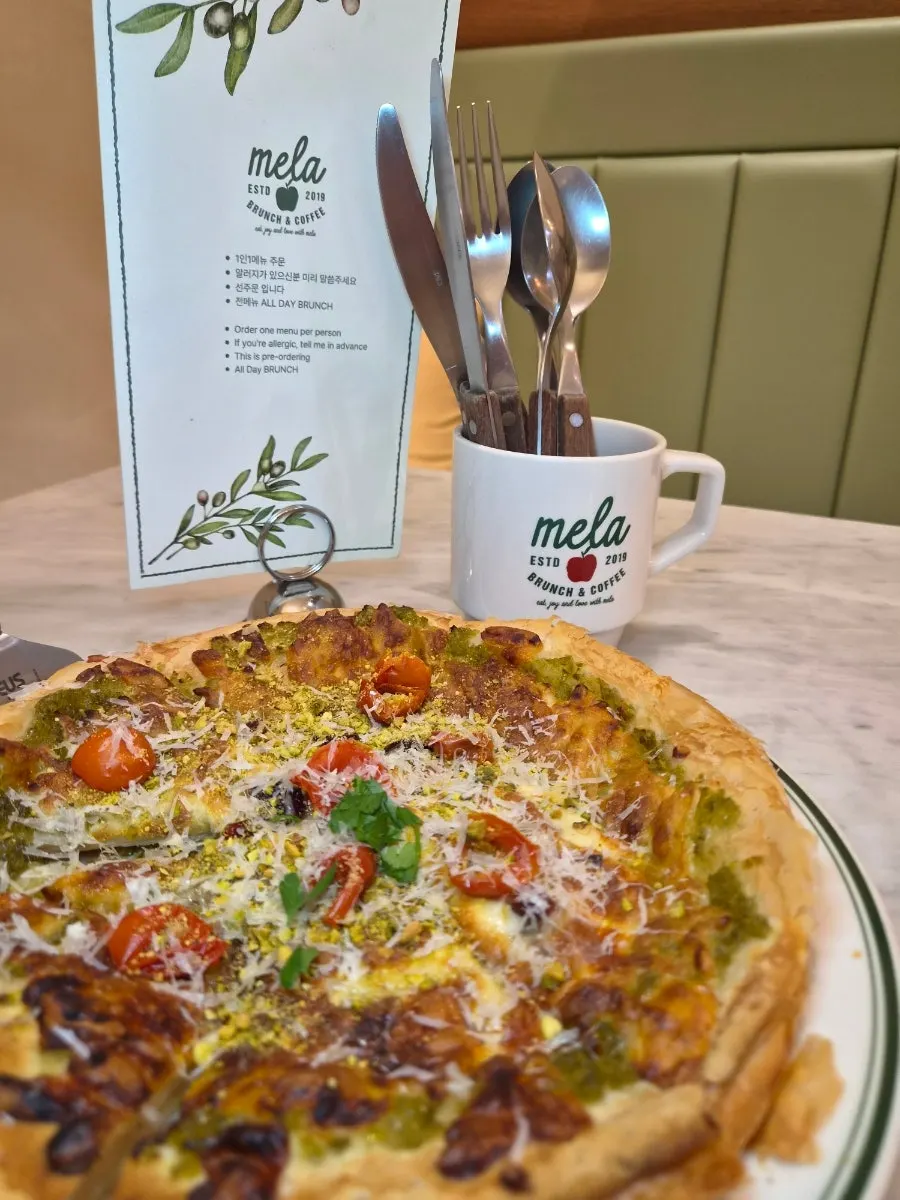 A lifted slice of pistachio jalapeño pizza