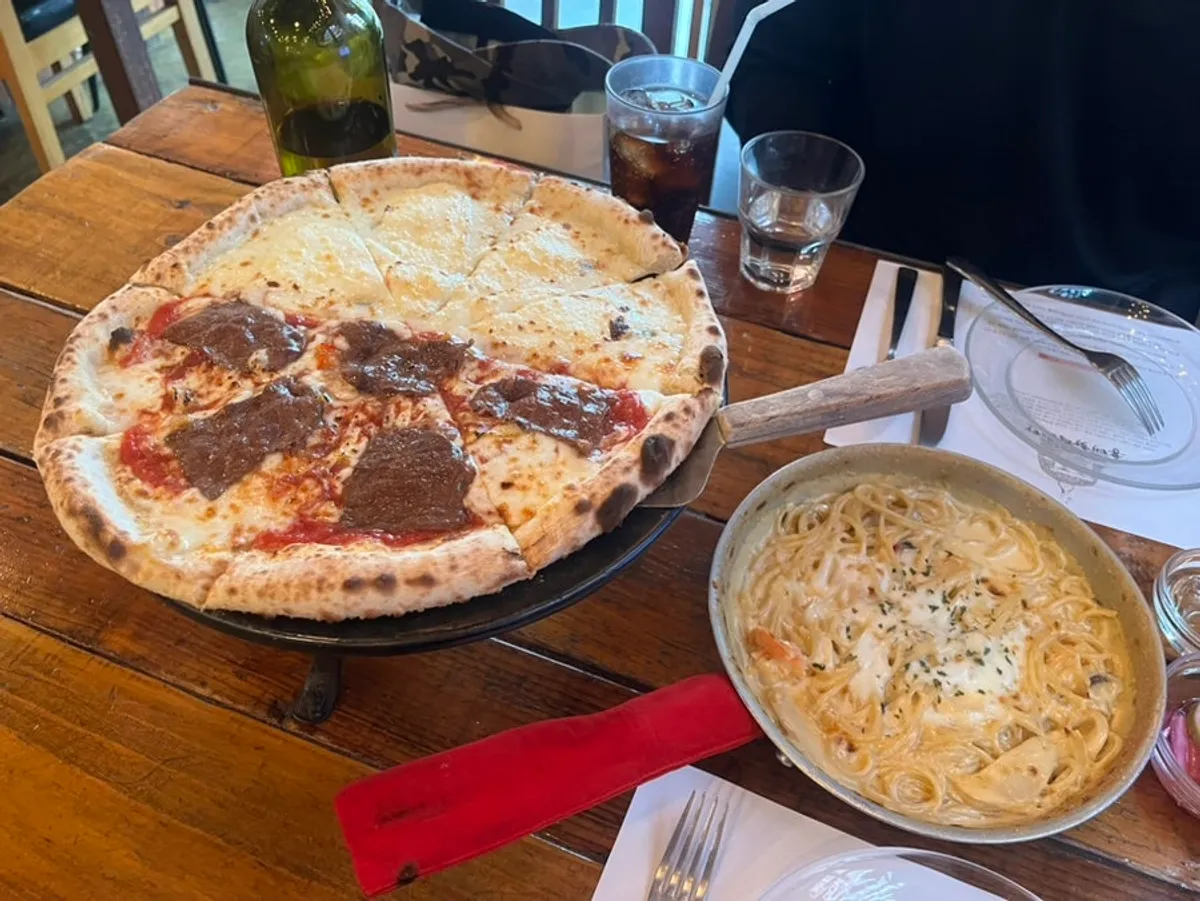 Full spread with half pizza and cream pasta