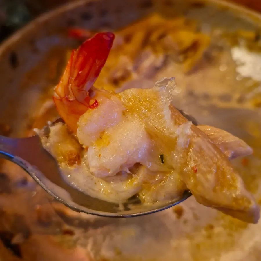 Close-up of shrimp cream pasta topped with arugula and shrimp