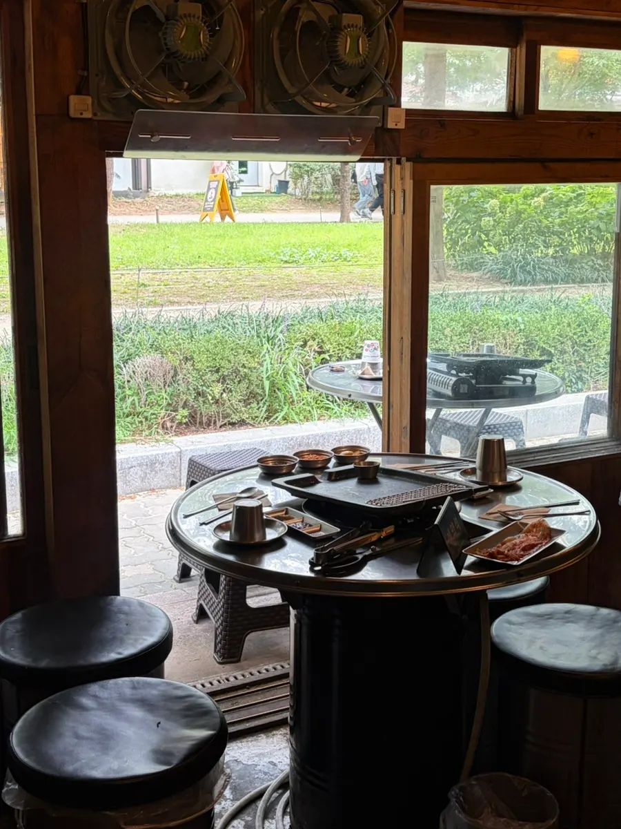Outdoor BBQ seating at Gogikkun Gimchunbae Hongdae Supgil Branch on a weekend afternoon