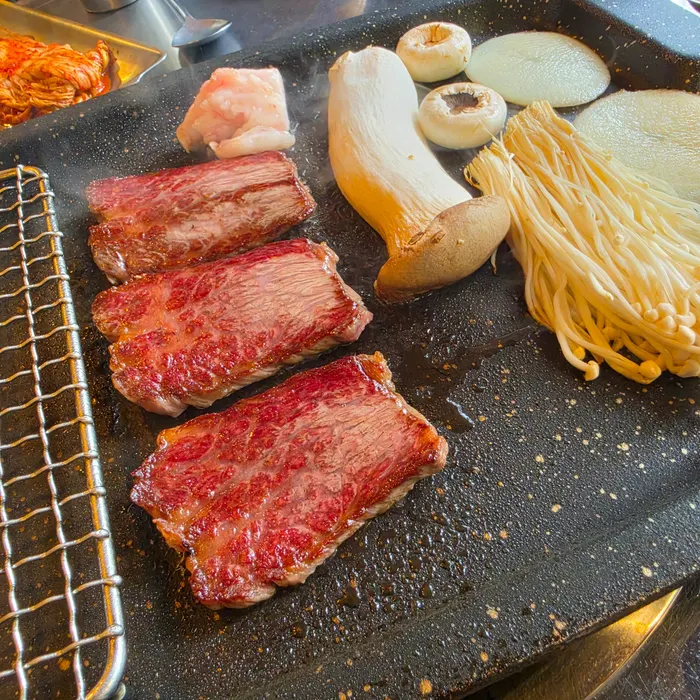Staff member grilling and cutting the meat