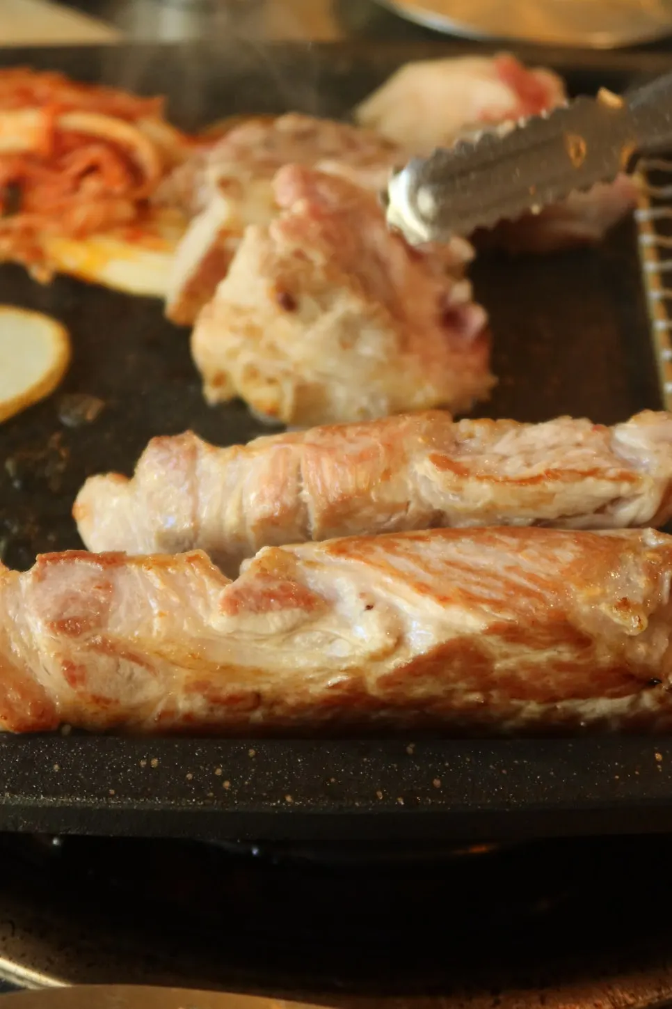 불판 가장자리에 놓인 버섯과 감자 가니쉬