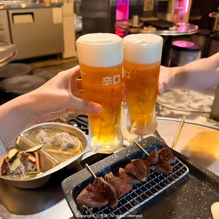 A glass of draft beer alongside the meat