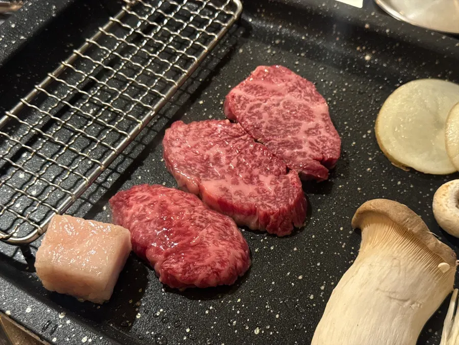 Staff grilling meat on the tabletop grill