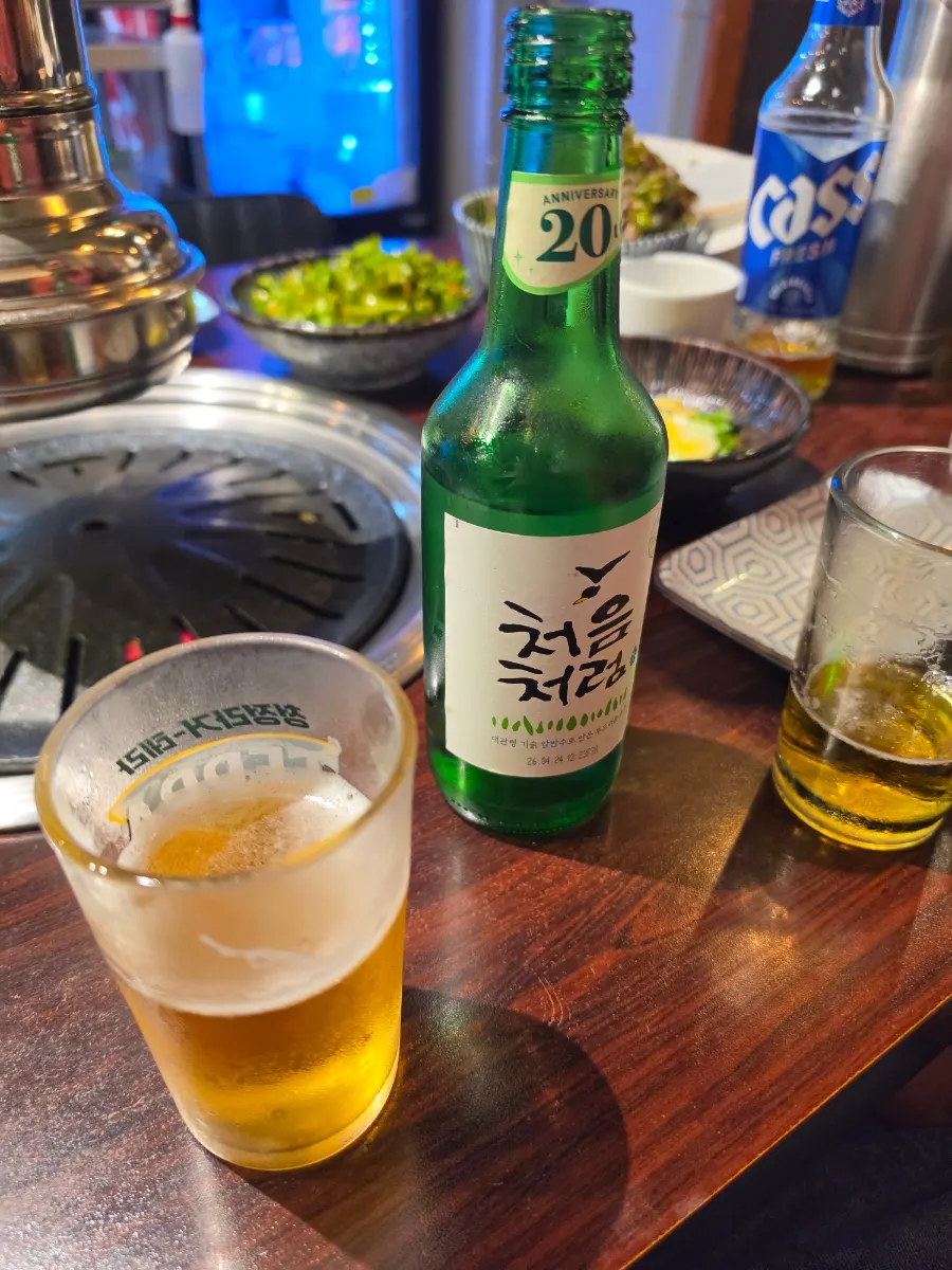 A glass of soju-beer alongside pork belly
