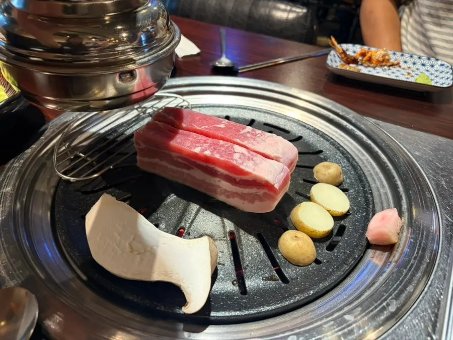 Raw pork belly and garlic on the grill