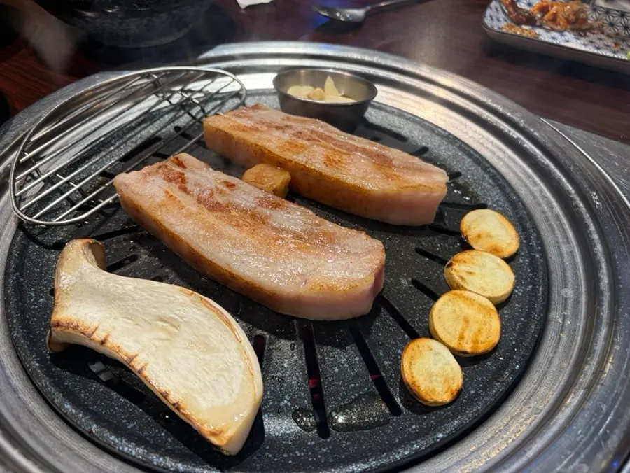 Staff member grilling the pork belly for us
