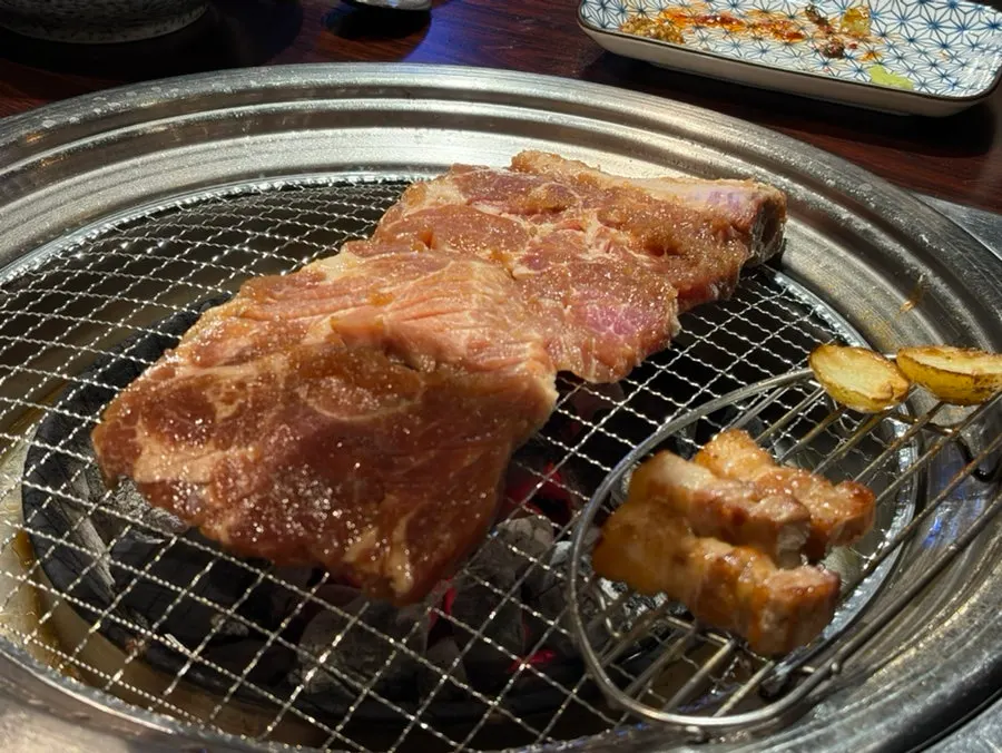 Whole piece of pork neck ribs on the grill