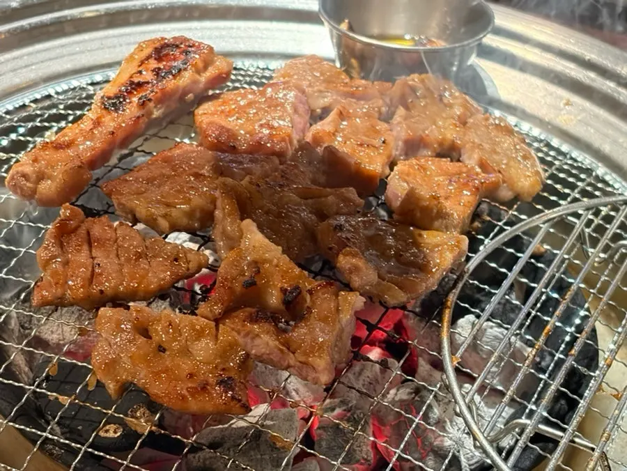 Staff grilling the pork neck ribs so the sauce doesn't burn