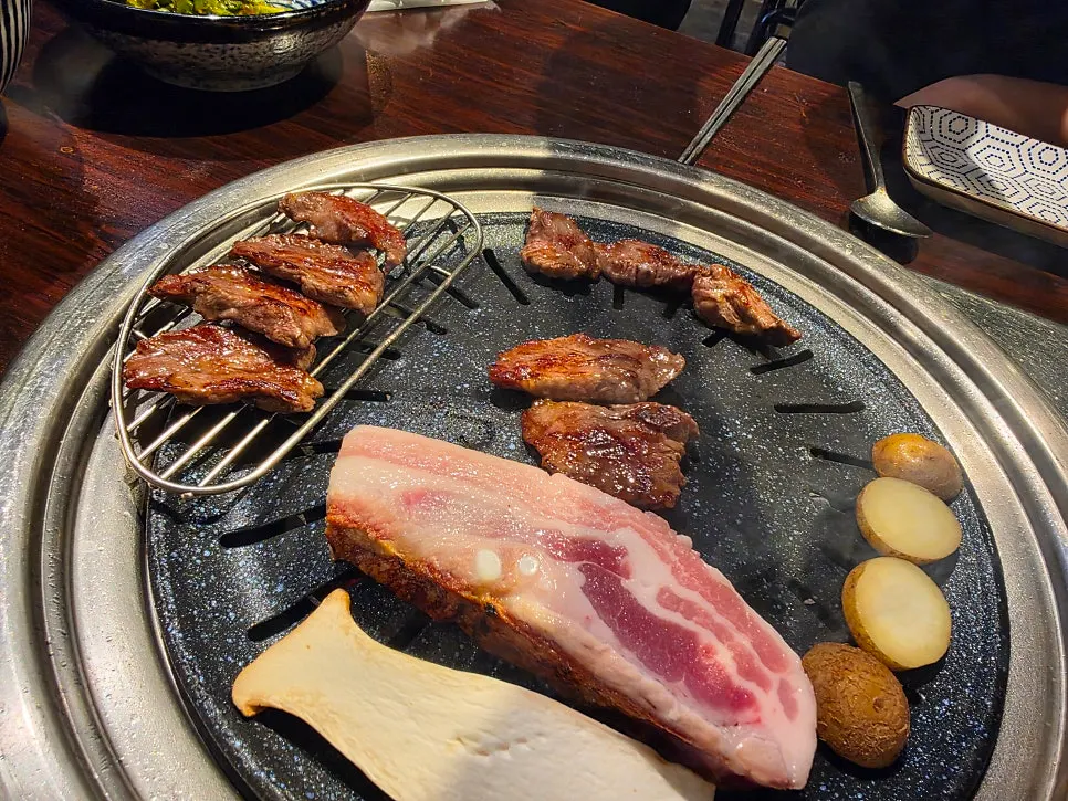 五花肉與配菜蔬菜一起煎烤的畫面