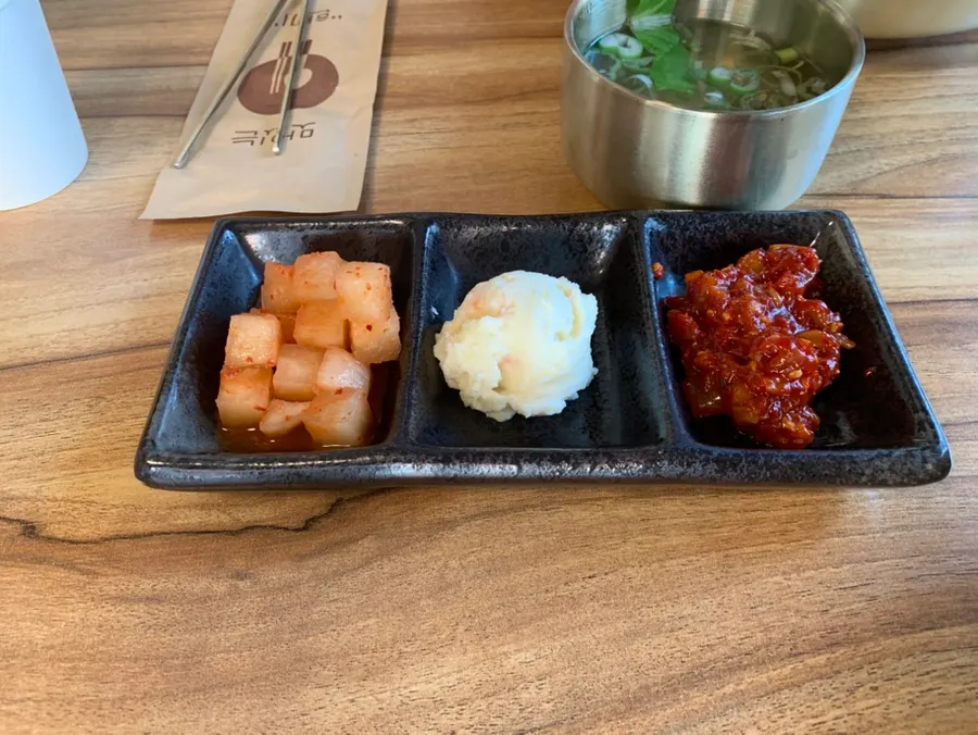 Side dishes of kkakdugi, potato salad, and seasoned octopus jeotgal