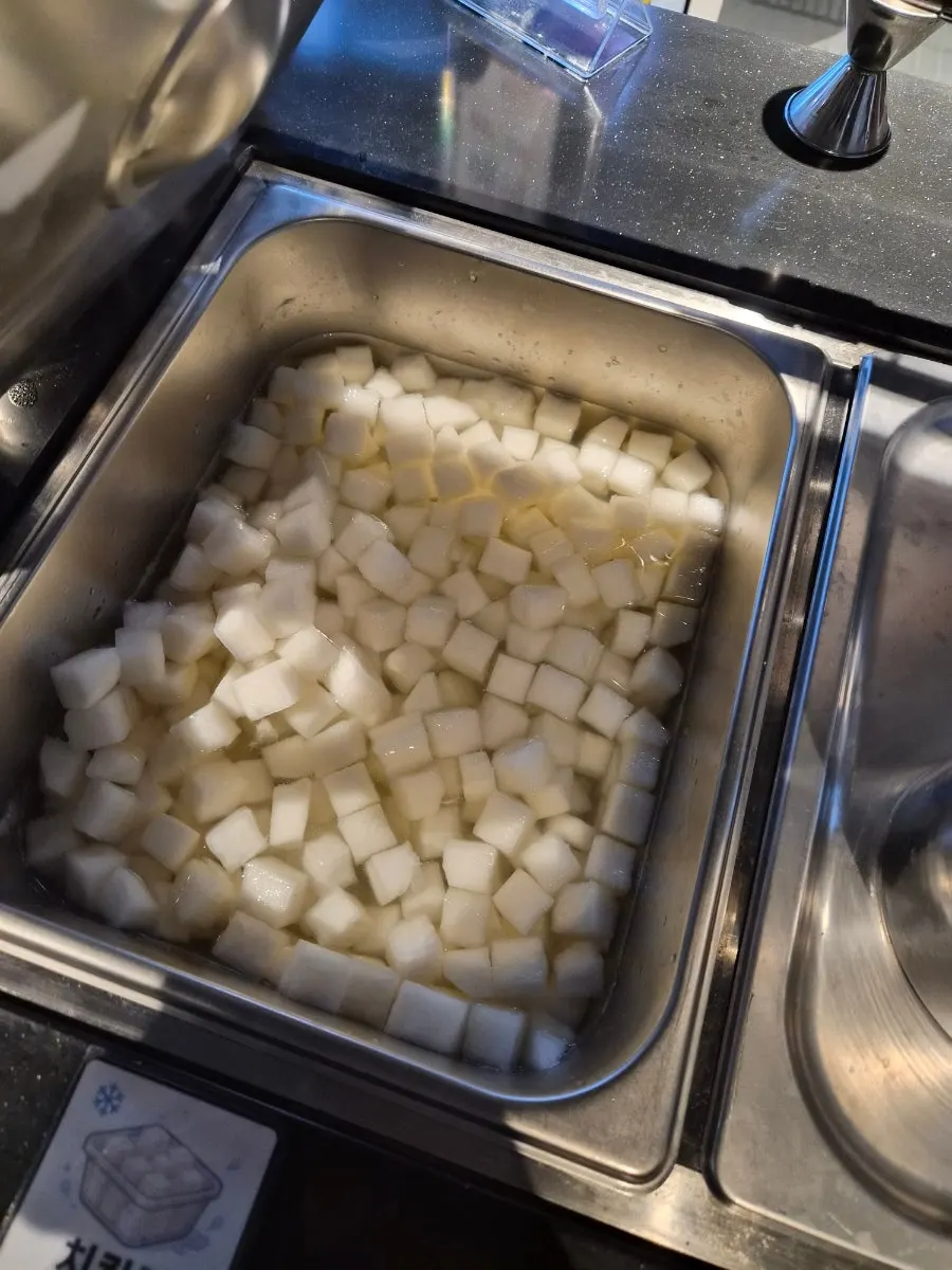 取り皿とチキン用大根の漬物が置かれたセルフバー