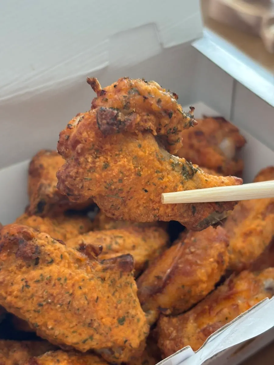 A piece of chicken with evenly coated seasoning
