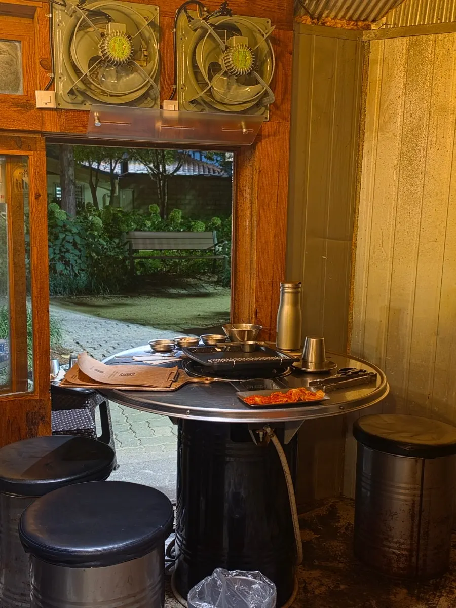 Spacious interior with open doors and round drum-can tables