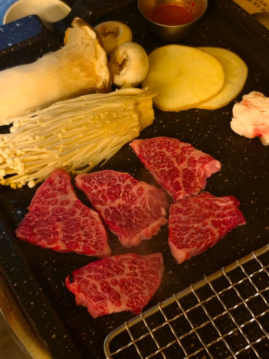 Staff member grilling meat on the grill plate