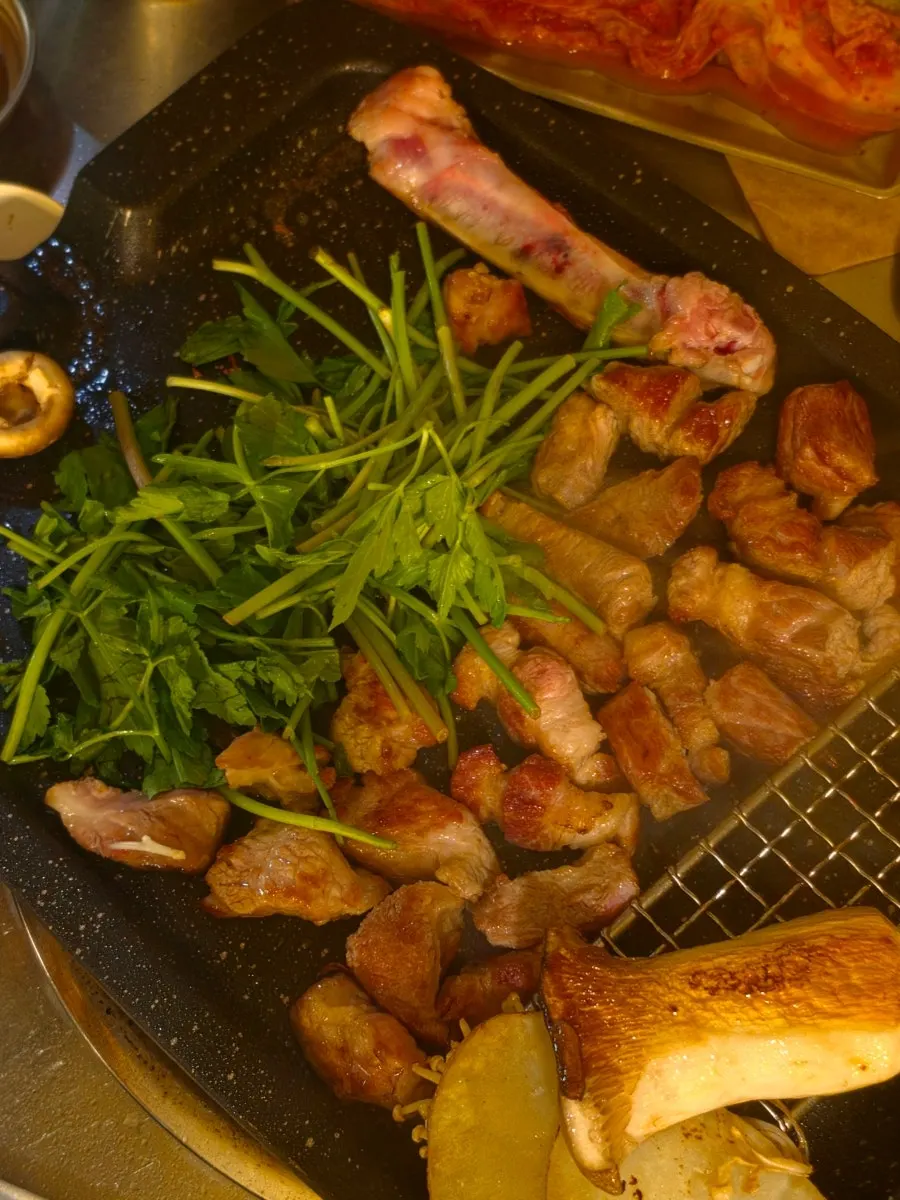 Pork neck and galbi cooking on the grill