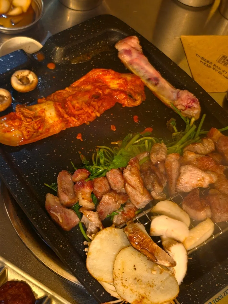 Minari and kimchi grilling alongside the meat