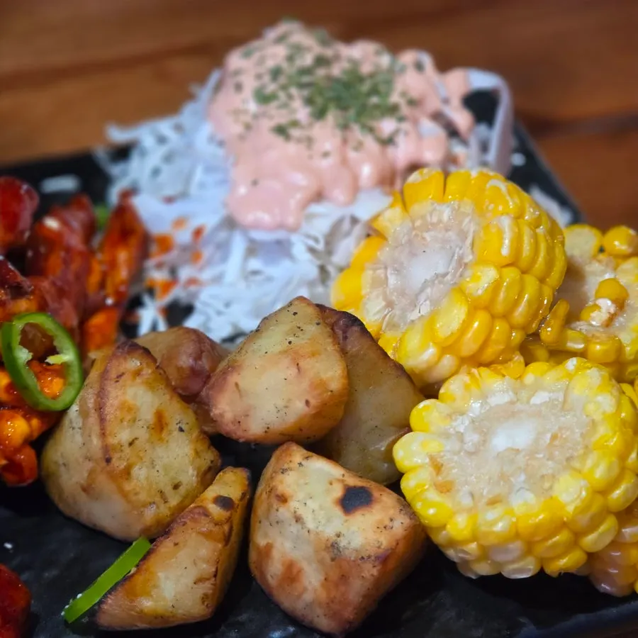 Salad and sweet potato and corn served alongside the chicken neck